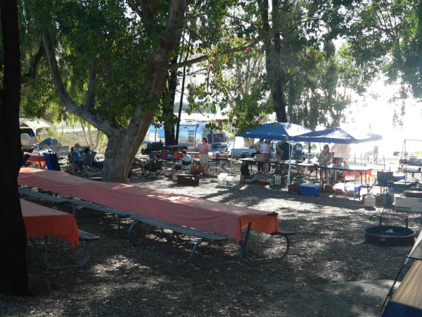 Early morning in camp, sun shining off the lake  Food prep area under the awnings.  We had the tables up above this year (because that's how we found them).  Worked well.