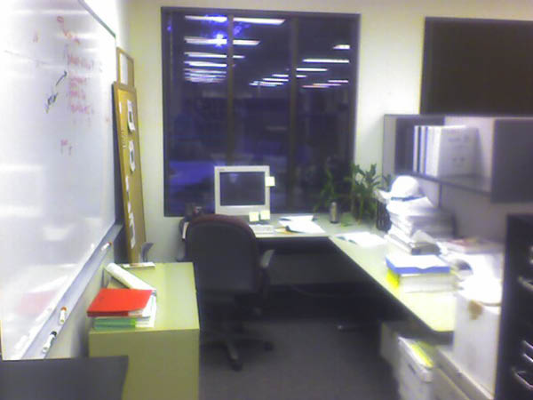 Ah, a much nicer picture of Greg Potemkin's cube.  Nice plant, too.  And he's got a lot of notes on his white board.
